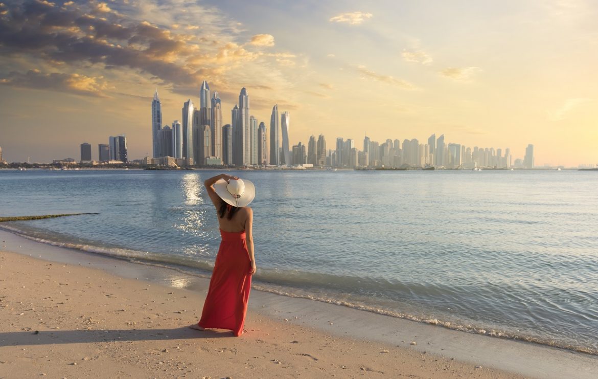 Beautiful and wealthy woman admiring the Dubai skyline