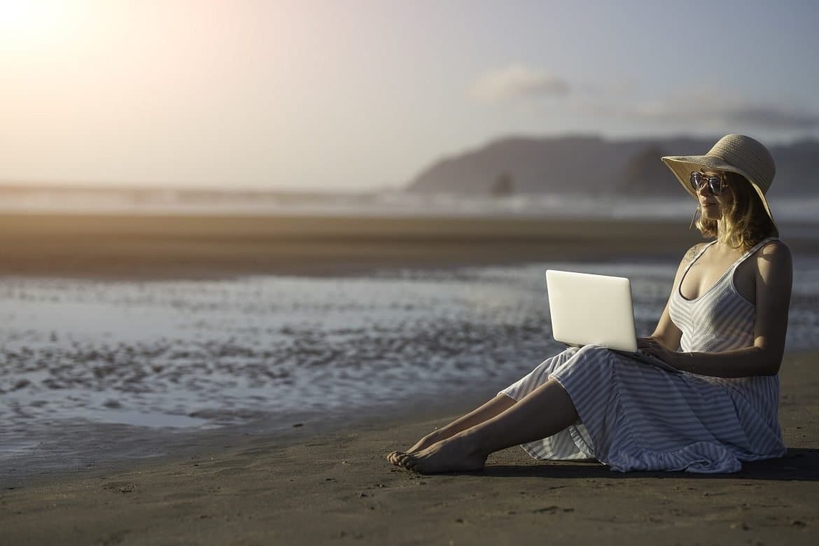 Young blogger works on a laptop at sunset, making money online